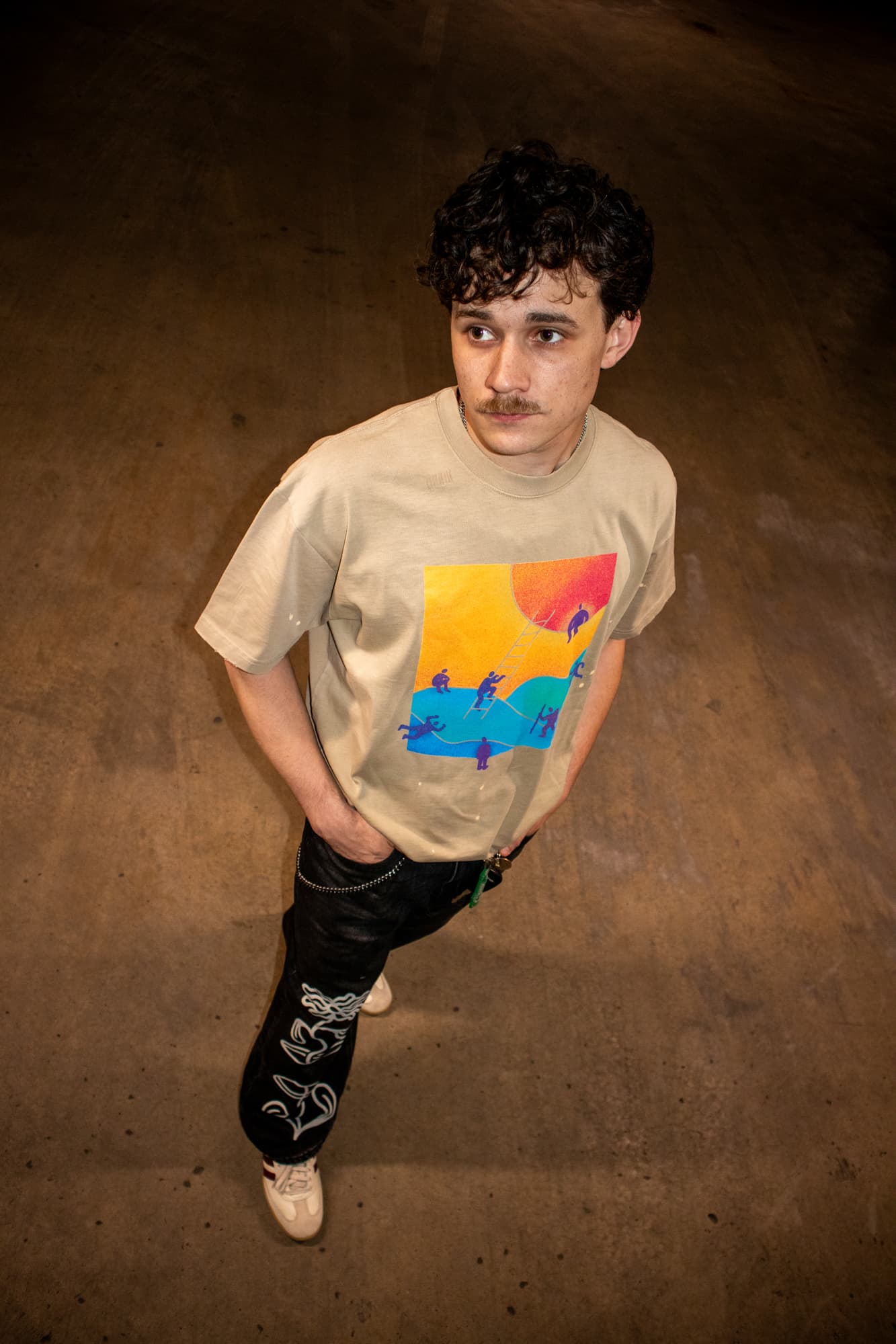 Model wearing the Ascend tee in apricot, overhead view of the front print
